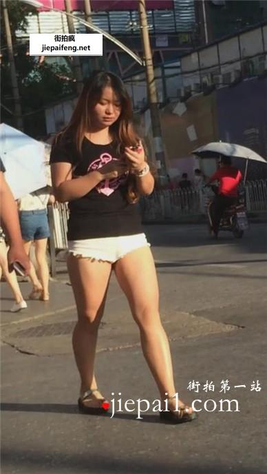 肥臀白短热裤女孩跟男友逛街。